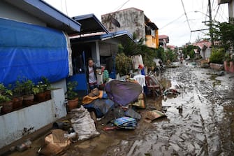 Residents clean their homes following flooding in Batangas City on November 2, 2020, after super Typhoon Goni made landfall in the Philippines on November 1. (Photo by TED ALJIBE / AFP) (Photo by TED ALJIBE/AFP via Getty Images)