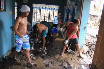 Residents clean their homes of lahar washed from the slopes of nearby Mayon volcano in Guinobatan town, Albay province on November 2, 2020, after super Typhoon Goni made landfall in the Philippines on November 1. (Photo by CHARISM SAYAT / AFP) (Photo by CHARISM SAYAT/AFP via Getty Images)