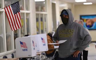 1229434106 A voters casts his ballot at a polling station on US Election Day in Winchester, Virginia early November 3, 2020. - Polling stations opened in New York, New Jersey and Virginia early November 3, marking the start of US Election Day as President Donald Trump seeks to beat forecasts and defeat challenger Joe Biden. The vote is widely seen as a referendum on Trump and his uniquely brash, bruising presidency that Biden urged Americans to end to restore "our democracy." (Photo by ANDREW CABALLERO-REYNOLDS / AFP) (Photo by ANDREW CABALLERO-REYNOLDS/AFP via Getty Images)