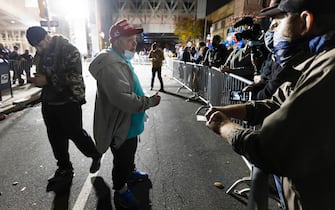 epa08802049 A Trump supporter (L) talks with Biden supporters (R) as people rally outside of the Pennsylvania Convention Center in Philadelphia, Pennsylvania, USA, 05 November 2020. Counting of mail-in ballots in Pennsylvania began on 03 November and is expected to stretch to 06 November.  EPA/JUSTIN LANE