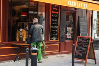 epa08800220 A waiter wearing a face mask asks a customer about his order, in a restaurant during lunchtime in Paris, France, 05 November 2020. Restaurants are allowed to remain open to provide take-out services as France re-intoduces lockdown measures in the midst of a second wave of the COVID-19 coronavirus pandemic, recording around 50,000 new cases daily  EPA/MOHAMMED BADRA