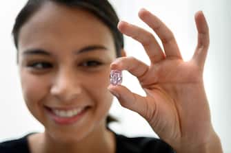 A model poses with the The Spirit of the Rose a rare 14.83 carats vivid purple pink diamond, during a press preview ahead of sales by Sotheby's auction house, in Geneva on November 6, 2020. - The exceptional ball-sized pink gem, shaped from the largest rough pink diamond ever discovered in Russia, will be offered in Geneva on 11 November by Sotheby's, which estimates it at between 23 and 38 million dollars. (Photo by Fabrice COFFRINI / AFP) (Photo by FABRICE COFFRINI/AFP via Getty Images)