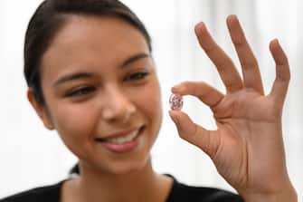 A model poses with the The Spirit of the Rose a rare 14.83 carats vivid purple pink diamond, during a press preview ahead of sales by Sotheby's auction house, in Geneva on November 6, 2020. - The exceptional ball-sized pink gem, shaped from the largest rough pink diamond ever discovered in Russia, will be offered in Geneva on 11 November by Sotheby's, which estimates it at between 23 and 38 million dollars. (Photo by Fabrice COFFRINI / AFP) (Photo by FABRICE COFFRINI/AFP via Getty Images)