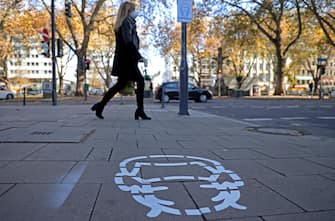 epa08811615 A pictogram indicating the wearing of a protective mask is painted on the pavement in the city centre of Duesseldorf, Germany, 10 November 2020. On 09 November the Administrative Court of Muenster decided that the general decree of the city of Duesseldorf concerning the obligation to wear masks in the city area is illegal. Throughout Germany, the number of cases of the COVID-19 disease caused by the SARS-CoV-2 coronavirus is rising.  EPA/FRIEDEMANN VOGEL