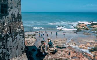 Men play football on the shores of the Cape Coast Castle on August 18, 2019. - African-American visitors are flocking to Ghana as it marks the "Year of Return" to remember the 400th anniversary of the first slave ship landing in Virginia. The West African nation is banking on the commemorations to give a major boost to the number of tourist arrivals as it encourages the descendants of slaves to "come home". Cape Coast Castle, 150 kilometres (90 miles) from the capital Accra, is a major magnet for those visiting. The white-washed fort lined with cannons was one of dozens of prisons studding the Atlantic coast where slaves were held before their journey to the New World. (Photo by NATALIJA GORMALOVA / AFP) (Photo by NATALIJA GORMALOVA/AFP via Getty Images)