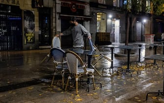 epa08774308 A bartender takes chairs and tables inside a bar in downtown Madrid, Spain, before a curfew was imposed late 25 October 2020.  A curfew from midnight to 06:00 am was imposed from last night in Madrid, after central Government's declared a new state of emergency in the country. Madrid's regional authorities have imposed mobility restrictions in 32 areas, as well, to try to avoid the spreading of COVID-19 virus disease.  EPA/Rodrigo Jimenez