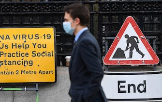 epa08811187 A pedestrian walks past a Coronavirus sign in London, Britain, 10 November 2020. The UK remains in its second national lockdown. This comes as news reports state that Covid-19 related deaths in Britain have increased by 46 percent in less than a week. Meanwhile British Prime Minister Boris Johnson has sated that a vaccine could be available by Christmas.  EPA/ANDY RAIN