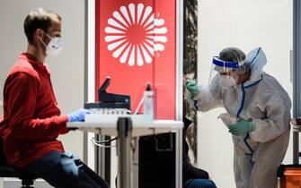 epa08800279 A health worker takes a test at a Covid-19 test center at Berlin Brandenburg Airport BER airport in Berlin, Germany, 05 November 2020. The company Centogene runs a walk-in COVID-19 test center at Berlin Brandenburg Airport and other airports in Germany.  EPA/CLEMENS BILAN