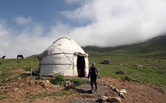 KYRGYZSTAN NOMADS epa04305817 A Kyrgyz boy walks in front of a typical yurta tent in a nomad camp located some 230 kilometers south of Bishkek, about 3,000 meters above sea level in a high steppe plateau of the Suusamyr Valley, Kyrgyzstan, 08 July 2014. The valley in Kyrgyzstan is famous for its 'Kumis', a fermented dairy product is traditionally made from mares' milk. Kumis is still part of the traditional daily nutrition of the nomad peoples. It is said to even help to cure tuberculosis and anemia and was a popular treatment in specialized Kumis sanatoriums in Russia in the 19th century. EPA/IGOR KOVALENKO