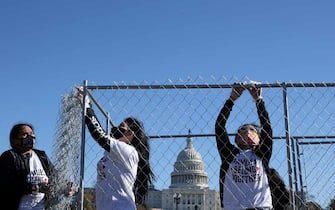WASHINGTON, DC - NOVEMBER 16: Volunteers from pro-immigration group Families Belong Together build a chainlink cage to fill with about 600 teddy bears 'representing the children still separated as a result of U.S. immigration policies' on the National Mall November 16, 2020 in Washington, DC. Organized by the National Domestic Workers Alliance, Families Belong Together was formed in 2018 in response to the Trump Administration's policy of separating children from their parents after they enter the U.S. to seek refuge, resulting in hundreds of children unable to be reunited with their families because of poor administration and tracking. (Photo by Chip Somodevilla/Getty Images)