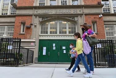 Students walk past a public school on October 5, 2020 in the Brooklyn Borough of New York City. - New York City Mayor Bill de Blasio said over the weekend he planned to reimpose restrictions on nine neighborhoods as Covid-19 cases rise in parts of the city, which had largely controlled the virus after a catastrophic outbreak. (Photo by Angela Weiss / AFP) (Photo by ANGELA WEISS/AFP via Getty Images)