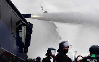 epa08827140 Riot police uses a water cannon to break up a demonstration against German coronavirus restrictions, near the Brandenburg Gate in Berlin, Germany, 18 November 2020. While German interior minister prohibited demonstrations around the Reichstag building during the parliamentary Bundestag session people gathered to protest against government-imposed semi-lockdown measures aimed at curbing the spread of the coronavirus pandemic. Since 02 November, all restaurants, bars, cultural venues, fitness studious, cinemas and sports halls are forced to close for four weeks as a lockdown measure to rein in skyrocketing coronavirus infection rates.  EPA/FILIP SINGER