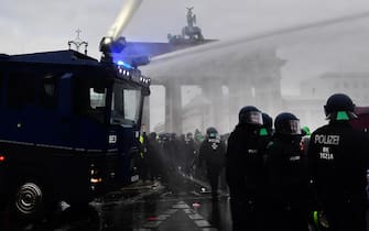 epa08827209 Riot police uses a water cannon to break up a demonstration against German coronavirus restrictions in front of the Brandenburg Gate in Berlin, Germany, 18 November 2020. While German interior minister prohibited demonstrations around the Reichstag building during the parliamentary Bundestag session people gathered to protest against government-imposed semi-lockdown measures aimed at curbing the spread of the coronavirus pandemic. Since 02 November, all restaurants, bars, cultural venues, fitness studious, cinemas and sports halls are forced to close for four weeks as a lockdown measure to rein in skyrocketing coronavirus infection rates.  EPA/FILIP SINGER
