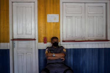 epa08822808 A military policeman guards the only electoral center of the Lago do Catalao community, in the rural area of Iranduba, Amazonas, Brazil, 15 November 2020. Brazilians go to the polls this Sunday to renew the mayors and councilors of 5,569 cities in the country, in a process that passed almost without incidents and under strict security measures due to covid-19. In Lago do Catalao, where all the houses are on the water, voters go by boat to cast their vote at the community school.  EPA/RAPHAEL ALVES