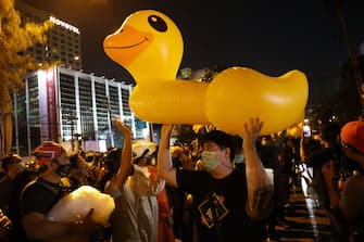 A man carries a large inflatable duck as pro-democracy protesters take part in an anti-government rally in Bangkok on November 18, 2020. (Photo by Jack TAYLOR / AFP) (Photo by JACK TAYLOR/AFP via Getty Images)
