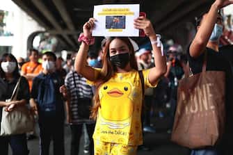 A protester wearing a yellow duck T-shirt and pants holds up a sign with a yellow duck photo during a 'Bad Student' rally in Bangkok on November 21, 2020. (Photo by Jack TAYLOR / AFP) (Photo by JACK TAYLOR/AFP via Getty Images)