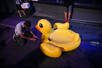 BANGKOK, THAILAND - NOVEMBER 21: A man bows in front of an inflatable yellow rubber duck in the Siam area on November 21, 2020 in Bangkok, Thailand. Pro-democracy protesters kept up the pressure on the Thai government with a protest organised by students on Saturday after tensions flared between demonstrators and police earlier in the week. (Photo by Sirachai Arunrugstichai/Getty Images)
