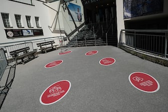 ISCHGL, AUSTRIA - SEPTEMBER 09: Stickers on the pavement explain social distancing and hygiene rules meant to minimize the risk of Covid-19 infection at the entrance to the Silvrettabahn ski lift, which was operating for summer tourists, on September 09, 2020 in Ischgl, Austria. Ischgl became a superspreader locality for coronavirus infections among winter vacationers last March and authorities have pointed to crowded apres-ski venues as a strong contributing factor. At least 28 people died and 6,000 people world-wide have registered with an Austrian lawyer claiming they think they were infected in Ischgl. Meanwhile Ischgl's hotels, restaurants, ski lift operator and other businesses that are dependent on tourism are taking measures they hope will bring tourists back for the coming winter ski season and minimize the risk of Covid infections.   (Photo by Sean Gallup/Getty Images)