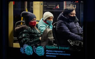 epa08846670 People wearing protective face mask ride on public transport during pandemic of SARS-CoV-2 coronavirus in Moscow, Russia 27 November 2020. According to official information, the highest number of new coronavirus infections over 24 hours since the beginning of the pandemic was recorded in Russia on 27 September.  EPA/YURI KOCHETKOV