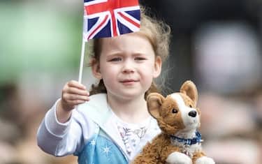 CHESTER, ENGLAND - JUNE 14: A young girl holds a flag and toy Corgi as well wishers line the route as the Duchess of Sussex and Queen Elizabeth II walk from Storyhouse to Chester Town Hall on June 14, 2018 in Chester, England. Meghan Markle married Prince Harry last month to become The Duchess of Sussex. This is her first engagement with the Queen. During the visit the pair opened a road bridge in Widnes, visited The Storyhouse in Chester followed by the Town Hall. (Photo by Anthony Devlin/Getty Images)
