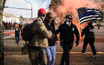 OLYMPIA, WA - DECEMBER 12: Demonstrators aid a Trump supporter who was beaten by counter-protesters during political clashes on December 12, 2020 in Olympia, Washington. Far-right and far-left groups squared off near the Washington State Capitol following violent clashes over the previous weekend. (Photo by David Ryder/Getty Images)