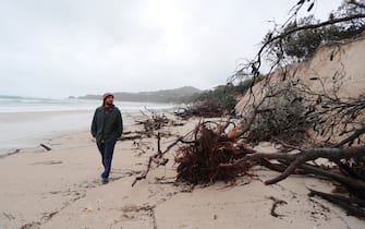 BYRON BAY, AUSTRALIA - DECEMBER 14:  Local resident Nick Colby checks the damage due to erosion along the beach side, December 14, 2020 in Byron Bay, Australia. Byron Bay's beaches face further erosion as wild weather and hazardous swells lash the northern NSW coastlines. (Photo by Regi Varghese/Getty Images)   