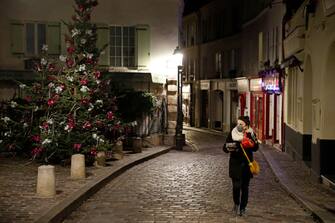 PARIS, FRANCE - DECEMBER 15: A woman wearing a protective face mask walks on a deserted street in Montmartre before the 8 p.m. nighttime curfew throughout the city during the coronavirus (COVID-19) outbreak on December 15, 2020 in Paris, France. A new curfew from 8:00 p.m. to 6:00 a.m. is in place in France from this evening and for an indefinite period to avoid a third wave of coronavirus infections. The curfew will be waived for Christmas Eve in order to allow families to travel to celebrate together but it will be kept in place for New Year's Eve. (Photo by Chesnot/Getty Images)