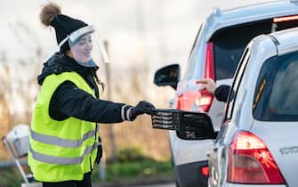 SWEDEN PANDEMIC CORONAVIRUS COVID19 epa08845362 A worker collects self-tests for ongoing Covid-19 infection at the sampling site in the car park at Svagertorp station in Malmo, Sweden, 27 November 2020. People with Coronavirus symptoms perform the pcr test themselves in their vehicles. At the sampling station at Svagertorp, about 200 samples are made every day. EPA/JOHAN NILSSON SWEDEN OUT