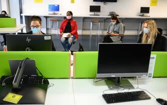 Students, wearing face masks to help mitigate the spread of the novel coronavirus COVID-19, work on computers in the Social Learning Zone at the University of Bolton, in Bolton, northern England on October 7, 2020. - The University of Bolton has introduced numerous Covid-safety measures across its campus including: airport-style temperature scanners, socially distanced seating, perspex screens and visors for lecturers, a bicycle loan scheme for students, one-way routes throughout campus buildings and additional online resources for student learning. Hundreds of thousands of students have begun a new academic year at universities across the UK. (Photo by OLI SCARFF / AFP) (Photo by OLI SCARFF/AFP via Getty Images)