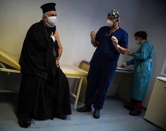 epa08905625 Bishop Tikhon of the Bulgarian Orthodox Church (L) is the second patient in Bulgaria to receive the Pfizer/BioNtech COVID-19 vaccine administered by ? doctor at  St. Anna  University Medical Center in Sofia, Bulgaria, 27 December 2020.  EPA/Borislav Troshev