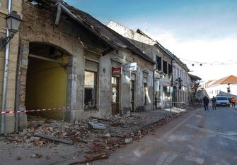 epa08909587 People stay on the street in front of the buildings damaged in an earthquake, in Petrinja, Croatia, 29 December 2020. A 6.4 magnitude earthquake struck around 3km west south west of the town with reports of many injuries and at least one death.  EPA/ANTONIO BAT
