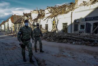 epa08909544 Croatian military police patrol in front of the buildings damaged in an earthquake, in Petrinja, Croatia, 29 December 2020. A 6.4 magnitude earthquake struck around 3km west south west of the town with reports of many injuries and at least one death.  EPA/ANTONIO BAT