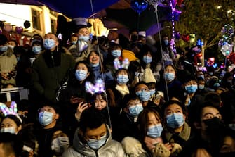 People wearing face masks attend a New Year's countdown in Wuhan in China s central Hubei province on December 31, 2020. (Photo by NOEL CELIS / AFP)