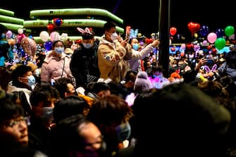 People wearing face masks attend a New Year's countdown in Wuhan in China s central Hubei province on December 31, 2020. (Photo by NOEL CELIS / AFP)