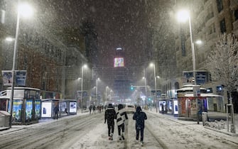 epa08927268 People walk at the Gran Via, central Madrid, Spain on 08 January 2021. A red warning has been issued in Madrid because of heavy snowfalls expected due to storm Filomena that has already caused a big drop in temperatures and snowfalls throughout Spain.  EPA/RODRIGO JIMENEZ