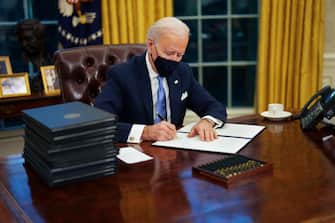 epaselect epa08954623 US President Joe Biden signs executive order on Covid-19 during his first minutes in the Oval Office, in the White House, Washington, DC, USA, 20 January 2021, following his inauguration as  46th President of the United States of America.  EPA/Doug Mills / POOL