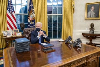 U.S. President Joe Biden prepares to sign executive orders in the Oval Office of the White House in Washington, D.C., U.S., on Wednesday, Jan. 20, 2021. Biden began his presidency with a soaring appeal to end Americas "uncivil war" and reset the tone in Washington, delivering an inaugural address that dispensed with a laundry list of policy goals to instead confront the nation's glaring political divides as the foremost obstacle to moving the country forward. Photographer: Doug Mills/The New York Times/Bloomberg via Getty Images