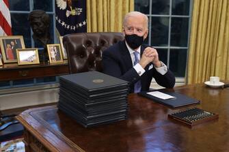 WASHINGTON, DC - JANUARY 20:  U.S. President Joe Biden prepares to sign a series of executive orders at the Resolute Desk in the Oval Office just hours after his inauguration on January 20, 2021 in Washington, DC. Biden became the 46th president of the United States earlier today during the ceremony at the U.S. Capitol.  (Photo by Chip Somodevilla/Getty Images)