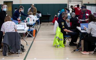 epa08940364 First Responders get their first dose of a Covid-19 vaccine shot, manufactured by Moderna, at a vaccination center set up in the Rumney Marsh Academy gymnasium in Revere, Massachusetts, USA, 15 January 2021. First responders are part of Phase One of the roll-out of vaccinations in the Commonwealth of Massachusetts.  EPA/CJ GUNTHER
