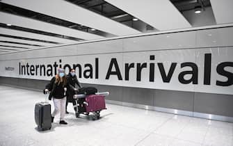 Viaggiatori nel'area degli arrivi internazionali dell'aeroporto di Londra Heathrow