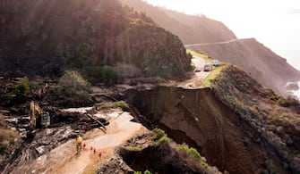 1230902780 Construction crews work on a section of Highway 1 which collapsed into the Pacific Ocean near Big Sur, California on January 31, 2021. - Heavy rains caused debris flows of trees, boulders and mud that washed out a 150-foot section of the road. (Photo by JOSH EDELSON / AFP) (Photo by JOSH EDELSON/AFP via Getty Images)