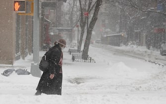epa08980177 A woman walks through the snow in Union Square, during a snowstorm in New York, New York, USA, 01 February 2021. According to reports, the moving storm brought about 15 cm (6 inches) of snow already and is expect to bring up to 50 cm (about 20 inches) of snow by Tuesday 02 February. The storm is causing hazardous travel conditions, flight cancellations.  EPA/JASON SZENES
