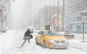 epa08980136 A woman hails a New York City Taxi along Union Square in New York, USA, 01 February 2021.  According to reports, the moving storm brought about 15 cm (6 inches) of snow already and is expect to bring up to 50 cm (about 20 inches) of snow by Tuesday 02 February. The storm is causing hazardous travel conditions, flight cancellations.  EPA/JASON SZENES