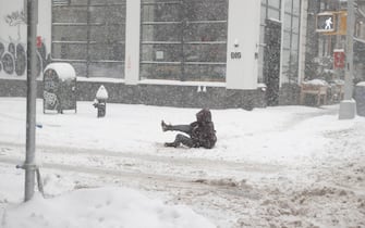 epa08980139 A woman slips as she tries to walk in the snow along the Union Square area in New York, USA, 01 February 2021. According to reports, the moving storm brought about 15 cm (6 inches) of snow already and is expect to bring up to 50 cm (about 20 inches) of snow by Tuesday 02 February. The storm is causing hazardous travel conditions, flight cancellations.  EPA/JASON SZENES