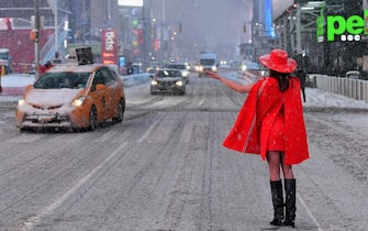 TOPSHOT - A woman stands in the snow at Times Square during a winter storm on February 1, 2021 in New York City. - A powerful winter storm is set to dump feet of snow along a stretch of the US east coast including New York City on February 1, 2021, after blanketing the nation's capital. The National Weather Service issued storm warnings from Virginia to Maine -- a swathe home to tens of millions of people -- and forecast snowfall of 18 to 24 inches (45-60 centimeters) in southern New York, northeastern New Jersey and parts of southwest Connecticut. (Photo by Angela Weiss / AFP)