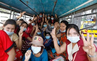 epa08990624 Protesters sitting inside a bus flash the three-finger salute, a symbol of resistance, as they gather to demonstrate against the military coup in Yangon, Myanmar, 06 February 2021. Teachers and students joined a nationwide strike as part of a civil disobedience campaign started by medical workers protesting against the recent military coup. Myanmar's Aung San Suu Kyi and other top political leaders were detained after the country's military seized power on 01 February amid allegations of voter fraud in the November 2020 elections.  EPA/NYEIN CHAN NAING