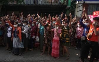 Protesters hold up the three finger salute during a demonstration against the military coup in Yangon on February 6, 2021. (Photo by STR / AFP)