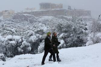 epa09015832 People make theirv way on Filoppapos hill, across Acropolis during heavy snowfall, in Athens, Greece, 16 February 2021. As the cold front Medea sweeping over Greece was in full progress and heading south, very low temperatures were recorded in the northern parts of the country.  EPA/ORESTIS PANAGIOTOU
