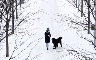 Feb 15, 2021; Cincinnati, OH, USA; Joelle Curtis walks her dog, Ranger, through the snow on Monday, Feb. 15, 2021, at Smale Riverfront Park in Cincinnati. The National Weather Service issued a winter storm warning starting Monday and going through 1 p.m. Tuesday. Heavy is snow expected, with total snow accumulations of 8-12 inches in Cincinnati, according to the National Weather Service.  Mandatory Credit: Albert Cesare-USA TODAY NETWORK/Sipa USA