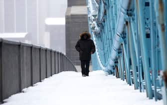 Feb 15, 2021; Cincinnati, OH, USA; A pedestrian walks across the Roebling Bridge through the snow from Cincinnati to Covington, Ky., on Monday, Feb. 15, 2021. The National Weather Service issued a winter storm warning starting Monday and going through 1 p.m. Tuesday. Heavy is snow expected, with total snow accumulations of 8-12 inches in Cincinnati, according to the National Weather Service.  Mandatory Credit: Albert Cesare-USA TODAY NETWORK/Sipa USA